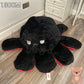 130cm reversible octopus plush toy with angry black face and red trim displayed on a wooden floor in a home setting.