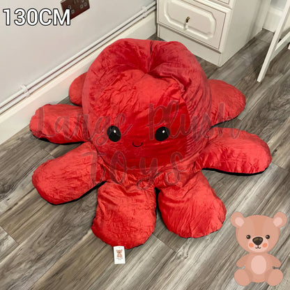 130cm reversible octopus plush toy with happy red face displayed on a wooden floor in a home setting.