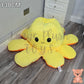 130cm yellow and orange reversible octopus plush toy with happy face displayed on a wooden floor.