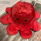 160cm reversible octopus plush toy with happy red face displayed on a wooden floor in a home setting.