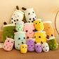 Stack of colorful plush toys resembling bubble tea cups on a wooden surface.
