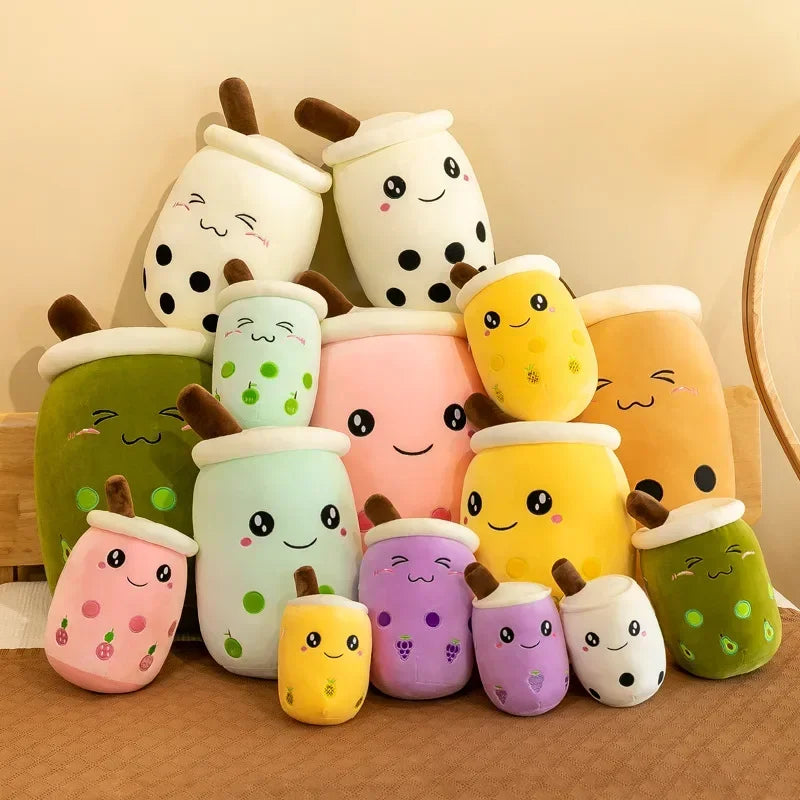 Stack of colorful plush toys resembling bubble tea cups on a wooden surface.