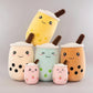 Set of colorful plush toys shaped like bubble tea cups with a person in the background.