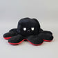 Black and red reversible octopus plush toy with angry expression displayed on a white background.