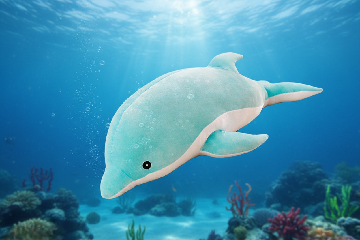 Blue dolphin plush toy swimming underwater above a coral reef with sunlight shining through the ocean.