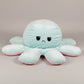 Blue and pink reversible octopus plush toy with angry face in a studio product photo on a light grey background.