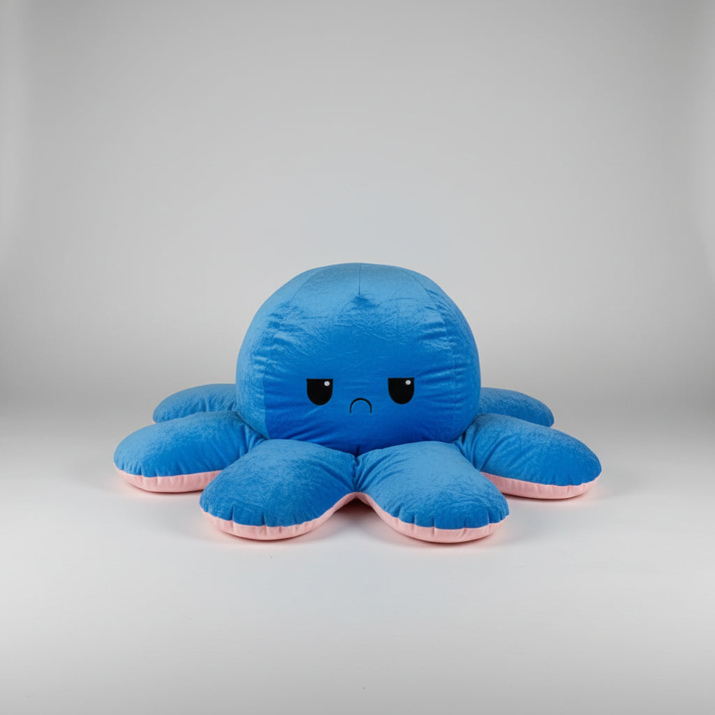 Blue and pink reversible octopus plush toy with angry face on a white background.