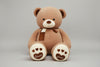 Brown teddy bear plush toy with heart paw details, soft scarf and cuddly stuffed design.