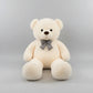 Large cream teddy bear plush toy with decorative bow tie soft stuffed animal gift for children and adults.