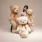 Giant teddy bear plush toys shown with a person for size comparison on a neutral studio background