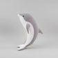 Grey and white dolphin plush toy standing upright on a light grey background.