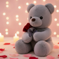 Grey teddy bear plush toy holding a red rose