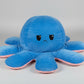 Large blue and pink reversible octopus plush toy with sad face on a white background.