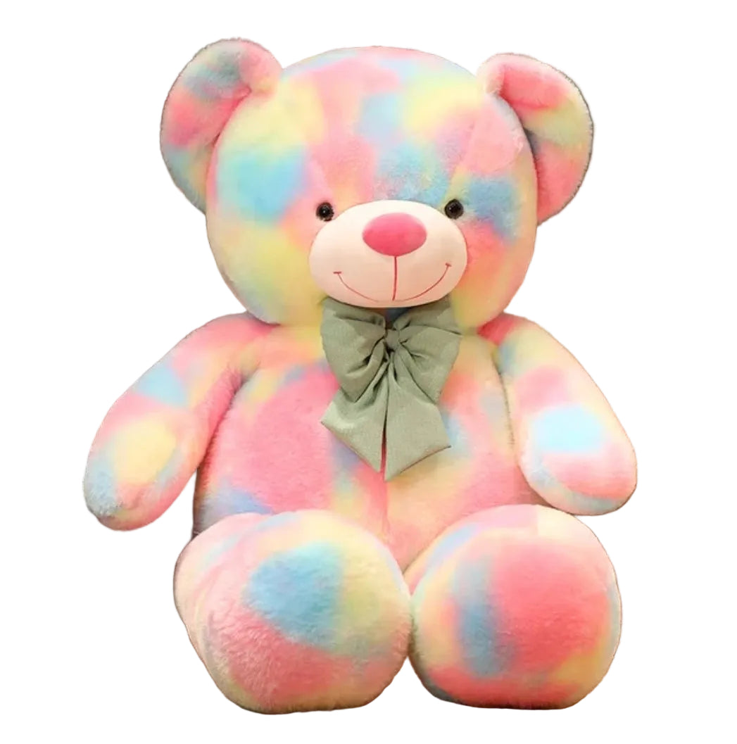 Large rainbow pastel teddy bear plush toy with a decorative bow sitting on a white background