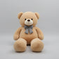Large light beige teddy bear plush toy with decorative bow tie soft stuffed animal gift for children and adults.