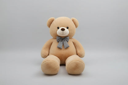 Large light beige teddy bear plush toy with decorative bow tie soft stuffed animal gift for children and adults.
