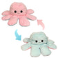Pastel pink and blue reversible octopus plush toy showing happy and angry expressions with flip design.