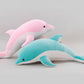 Pink and blue dolphin plush toys layered together on a light grey background