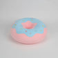 Pink donut plush pillow with blue frosting and colourful sprinkle design made from soft plush fabric.