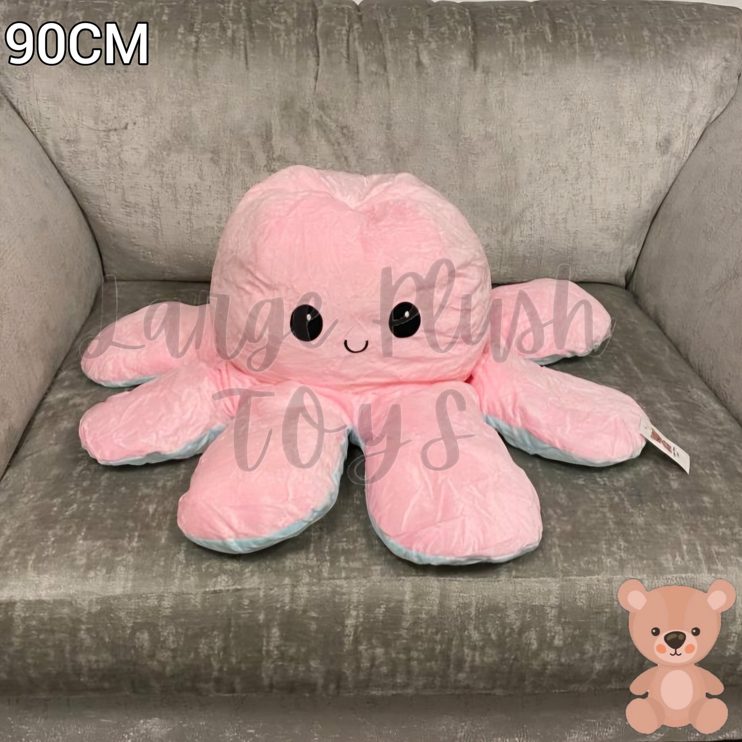 90cm pink and blue reversible octopus plush toy with happy face displayed on a grey armchair.