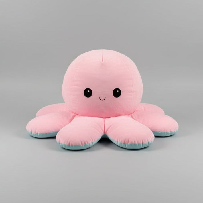 Pink and blue reversible octopus plush toy with happy face on a light grey background.