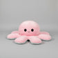 Pink and blue reversible octopus plush toy with happy face in a studio product photo on a light grey background.