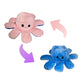 Pink and blue reversible octopus plush toy showing happy and angry expressions with flip arrows on a white background.