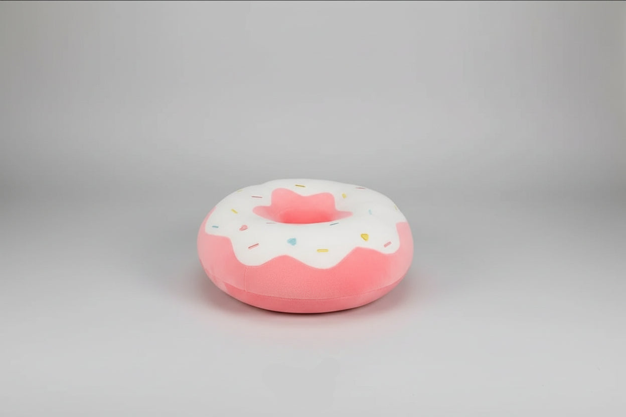 Pink donut plush pillow with white icing, colourful sprinkles and soft stuffed cushion design.