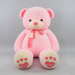 Pink teddy bear plush toy with love heart details, soft scarf and embroidered paw design.