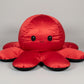 Red and black reversible octopus plush toy with happy face displayed on a white background.