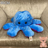 90cm reversible blue and purple octopus plush toy with happy expression, oversized soft stuffed cushion displayed on an armchair.