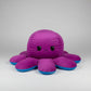 Reversible blue and purple octopus plush toy with angry expression, soft stuffed cushion shown from the front on a white background.
