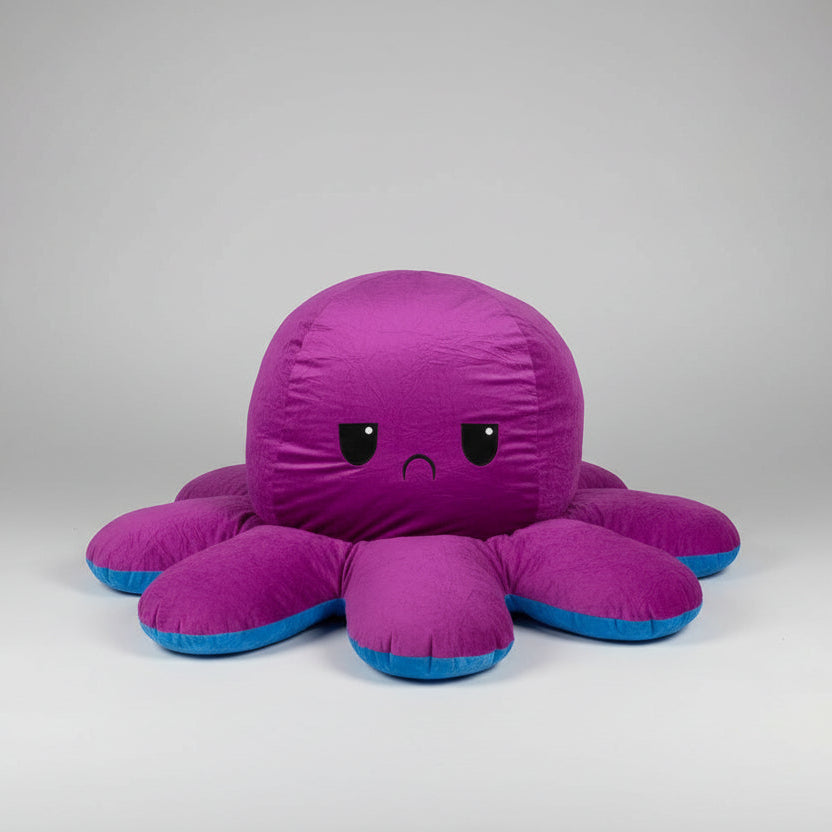 Reversible blue and purple octopus plush toy with angry expression, soft stuffed cushion shown from the front on a white background.