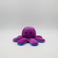 Small reversible purple and blue octopus plush toy with angry expression, soft stuffed cushion displayed on a white background.