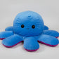 Large reversible blue and purple octopus plush toy with happy expression, soft stuffed cushion displayed on a white background.