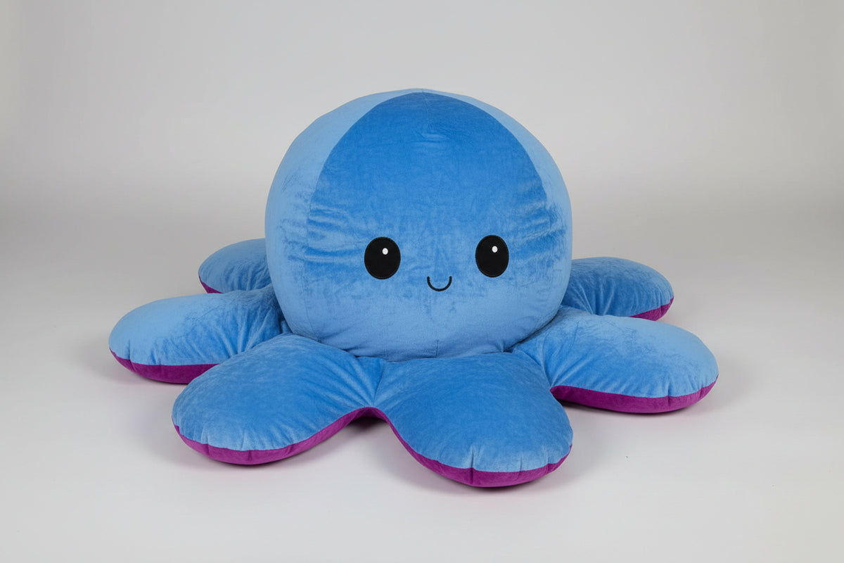 Reversible blue and purple octopus plush toy with happy expression, soft stuffed cushion shown from the front on a white background.