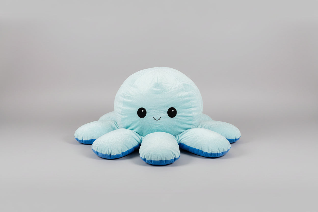 Pastel blue reversible octopus plush toy with a happy smiling face, soft stuffed cushion for kids, sensory play and bedroom decor.