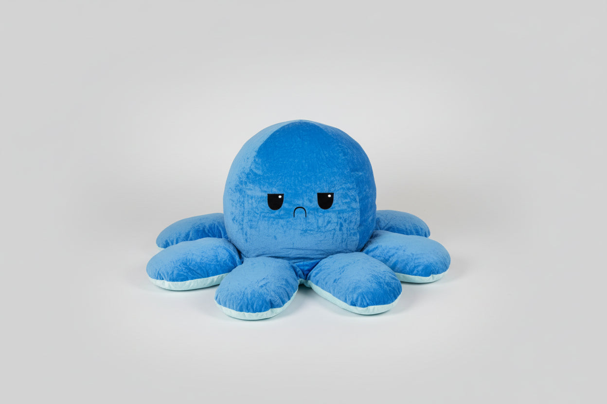 Pastel blue reversible octopus plush toy with a sad expression, soft stuffed cushion for children, sensory play, emotional learning and bedroom decor.