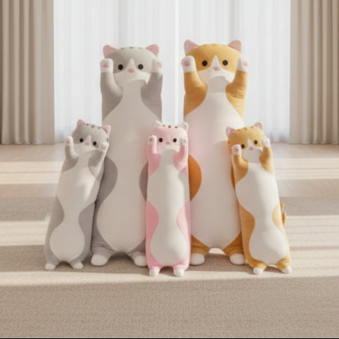 Standing cat plush toy family collection in grey, pink and orange colours displayed together in a bright living room.