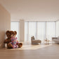Large teddy bear and small pastel teddy bear plush toys displayed in a modern living room setting