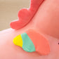 Close-up detail of a pink unicorn plush toy showing a pastel rainbow wing and soft fabric texture.