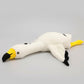 White swan plush toy lying flat on a white background