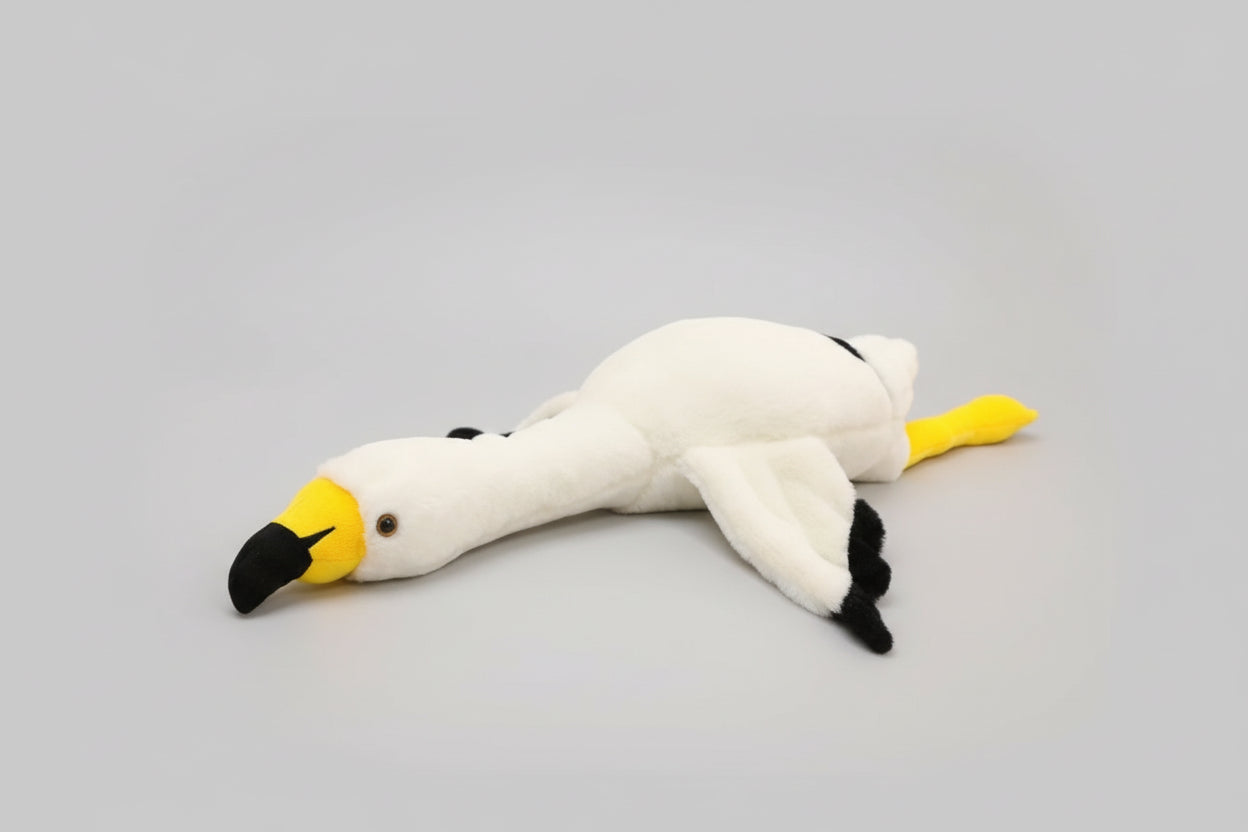 White swan plush toy lying flat on a white background